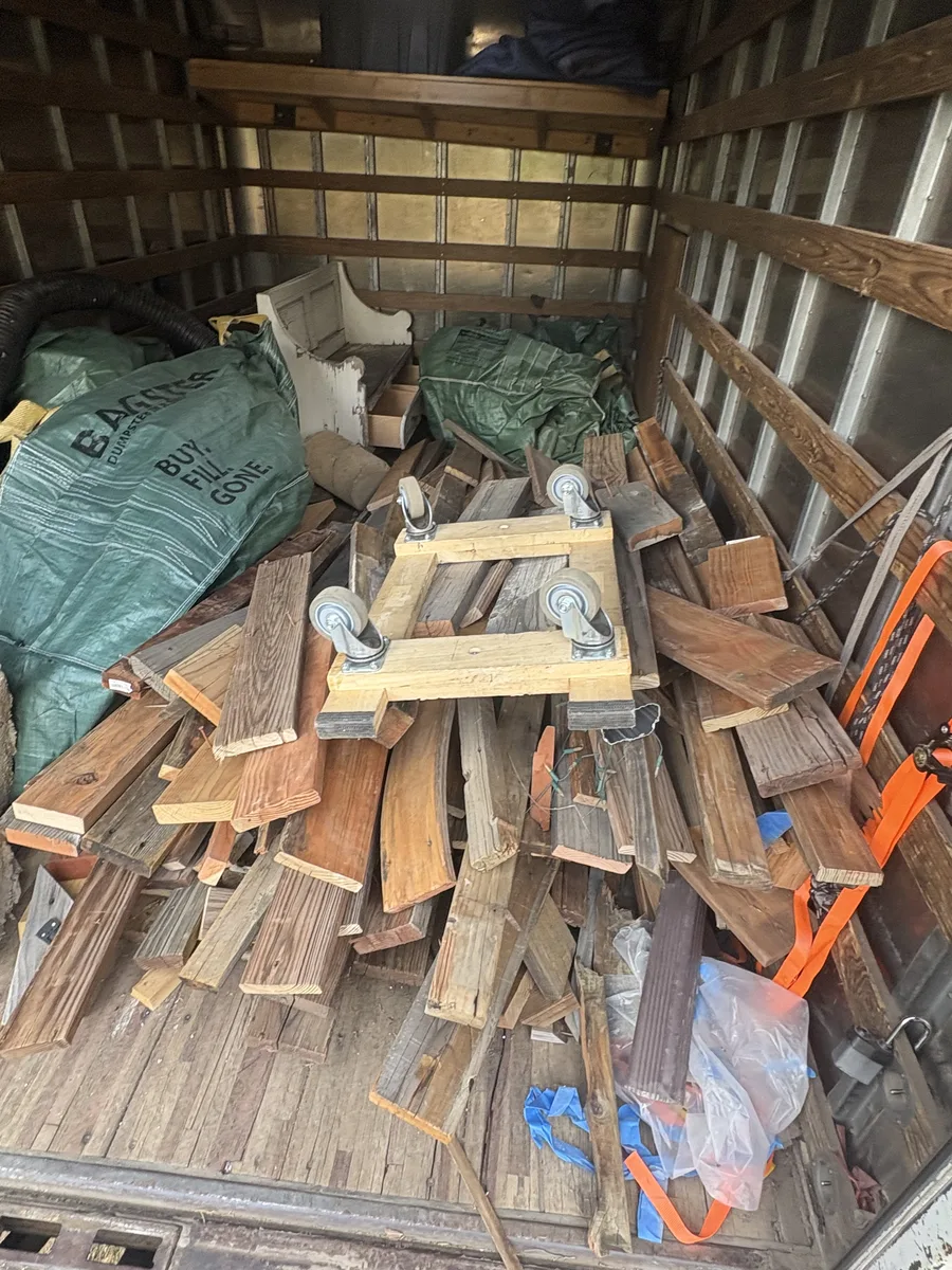 Inside the box truck loaded with deck lumber, a dolly, and the Bagster bags
